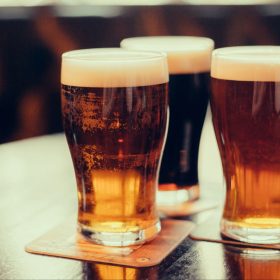 3 pints of beer on a pub table.