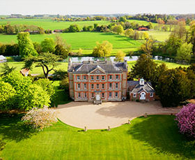 Oxfordshire country manor with green lawns and rolling hills.