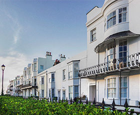Large white houses with balcony overlooking the sea in Sussex.