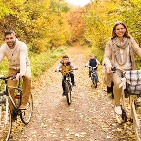 Family cycling in the forest.