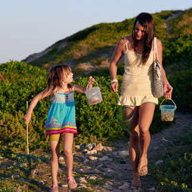 Mum and daughter walking together after going fishing at the beach.