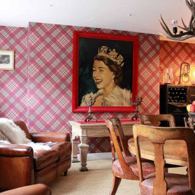 Quirky room with a big painting of the queen in vibrant colours!