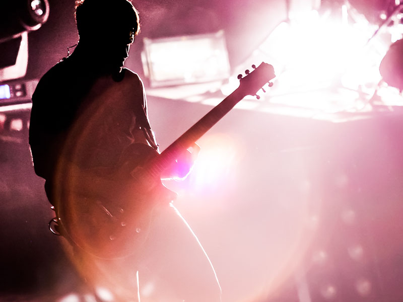 A man playing the guitar at a music venue.