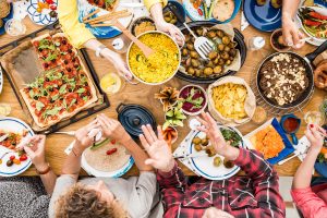 A table full of food with people enjoying a meal.