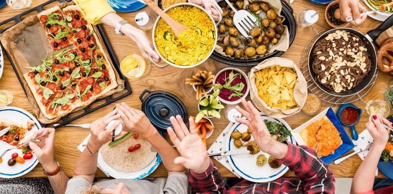 A table full of food with people enjoying a meal.