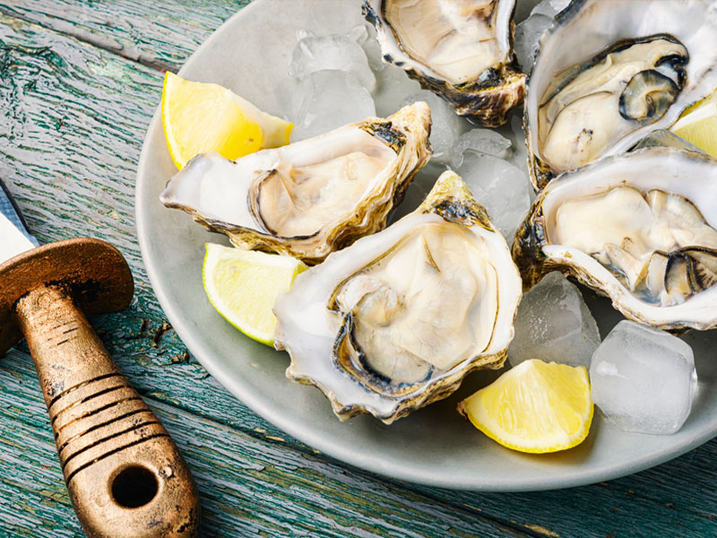 Oysters on a plate with some lemons.