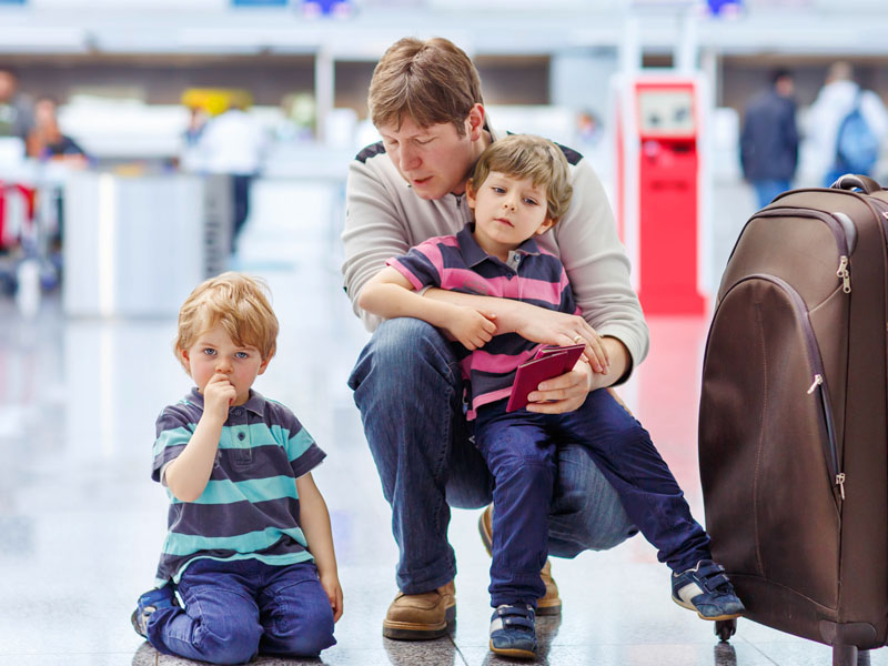 Tired father and two little sibling kids boys at the airport, 