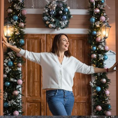 A lady standing outside a large house for New Year’s Eve.