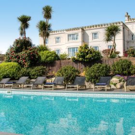 The tranquil pool at Polpier, framed by classic architecture and vibrant landscaping